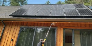 Professional soft washing of roof-mounted solar panels on a residential home