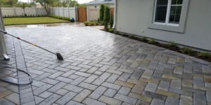 A wet paver patio being cleaned before sealing, a key step that affects the total paver cleaning and sealing cost.