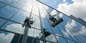 Professional building exterior cleaning services with workers washing high-rise windows in safety gear.
